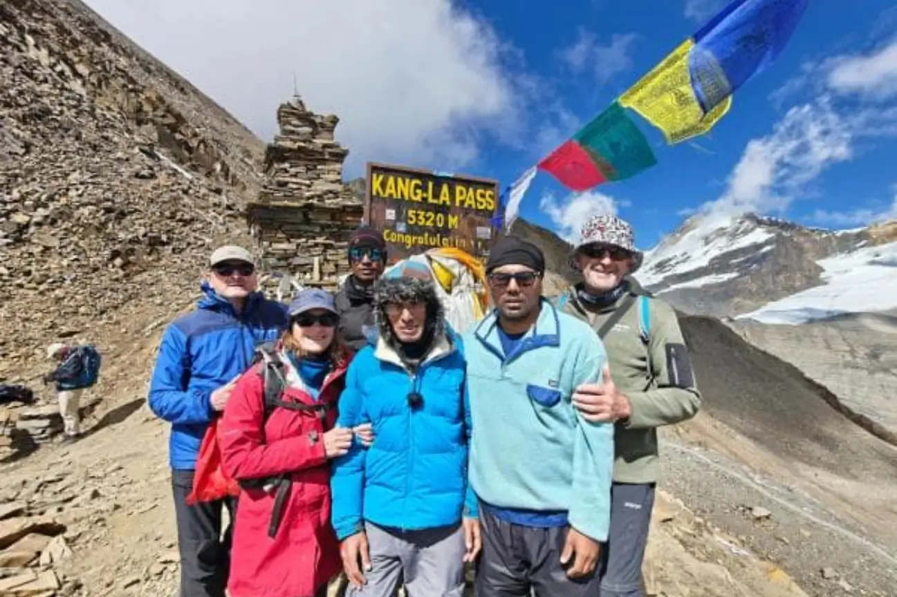 A group of close friends posing together at the Kang La Pass summit during Nepal trek tours.